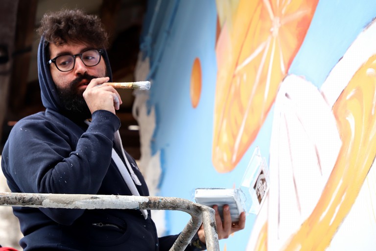 Lorenzo Tomacelli durante la realizzazione del murales